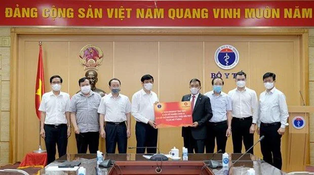 image of conglomerate vingroup presenting the toke of the covid-19 breath testing 
system to the health ministry